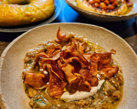 aubergine dip with artichoke crisps in a pottery bowl on a table