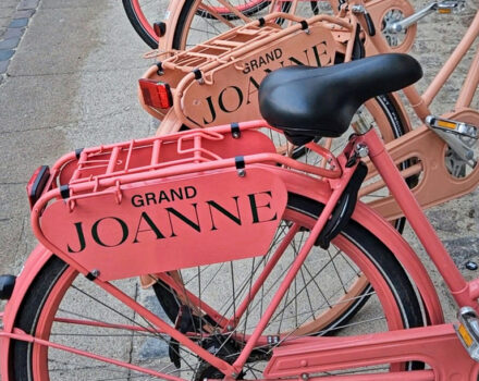 pink bicycles lined up with hotel branding on the back